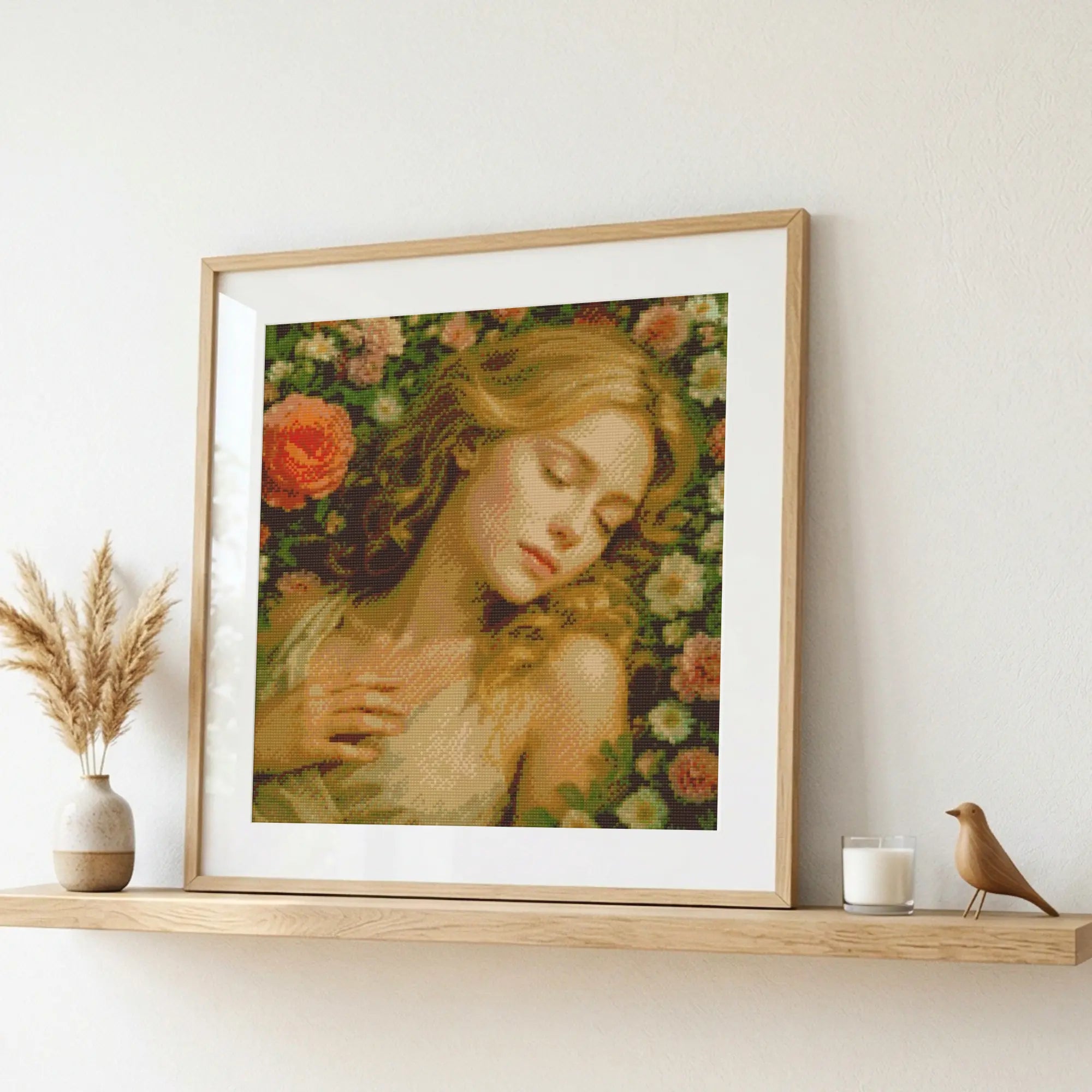 Framed artwork of a woman with flowers on a shelf with decorative items. Sleeping Beauty in Rose Garden | Diamond Painting Kit